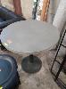 46 · ROUND PEDESTAL TABLE. BLACK STEEL BASE WITH COMPOSITE TOP, GREY. 765 X 800 MM (HEIGHT DIAMETER).